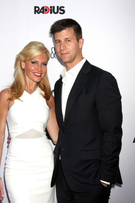 Ashley Bernon in a white dress poses for a picture with Paul Bernon.